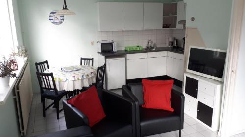 Il comprend une cuisine et un salon avec une table et des chaises. dans l'établissement Duinnachtegaal, à Egmond aan Zee