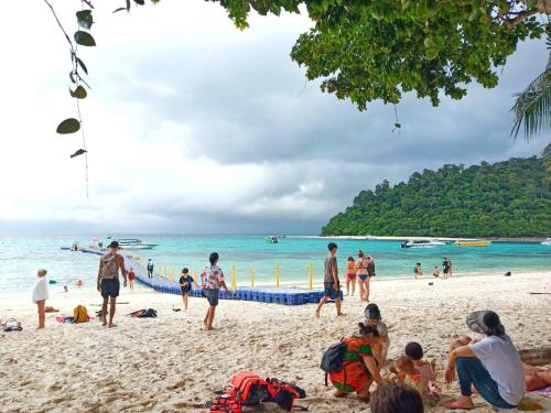 a group of people playing volleyball on a beach at Som PalmGarden in Ko Lanta