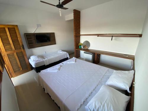 a bedroom with two beds and a ceiling fan at Pousada Portal do Prado in Prado
