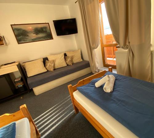 a living room with two beds and a couch at Penzión Vila Petra Bed&Breakfast in Veľký Slavkov