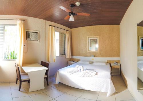 a bedroom with a bed and a ceiling fan at Hotel Termas da Guarda in Tubarão