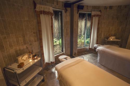 een slaapkamer met 2 bedden, een wastafel en ramen bij Iberostar Cozumel - All Inclusive in Cozumel