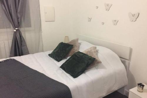 een bed met twee groene kussens erop bij F3 agréable et calme in Château-Thierry