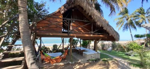 a tree house on the beach with a hammock at Pousada Lacula in Praia de Moitas