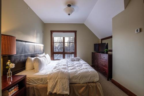 a bedroom with a large bed and a window at Étoile du Matin by Rendez-Vous Mont-Tremblant in Mont-Tremblant