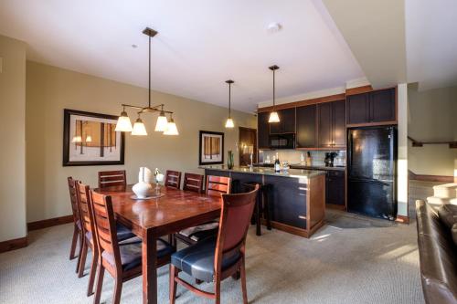 a kitchen and dining room with a wooden table and chairs at Étoile du Matin by Rendez-Vous Mont-Tremblant in Mont-Tremblant