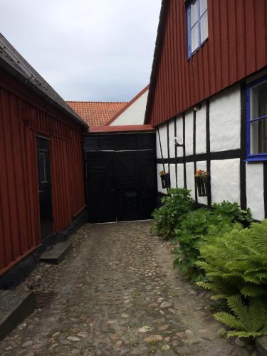 a black and white building with a red roof at Gårdshus Torget Åhus in Åhus