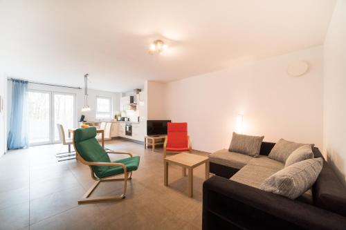 ヴィースバーデンにあるTownus Apartments Wiesbadenのリビングルーム(ソファ、椅子付)