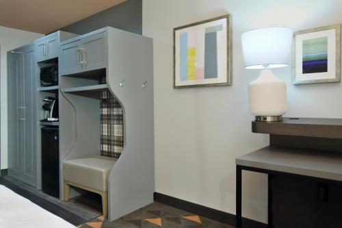 a stairway in a living room with a lamp and a chair at Holiday Inn Hattiesburg - North by IHG in Hattiesburg