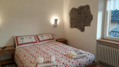 een slaapkamer met een bed met twee handdoeken erop bij B&B Cuore Trentino in Baselga di Pinè