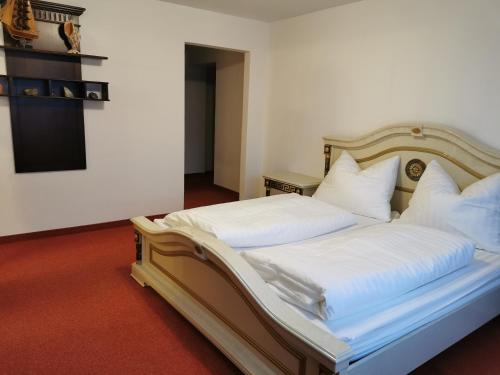 1 dormitorio con 1 cama con sábanas y almohadas blancas en Ferienwohnung Außerdorf en Wiesing