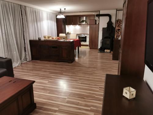 ein Wohnzimmer mit Holzboden und eine Küche in der Unterkunft Ferienwohnung Außerdorf in Wiesing
