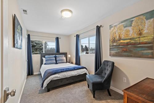 a bedroom with a bed and a chair and a window at The Cottage On The Corner in Coeur d'Alene