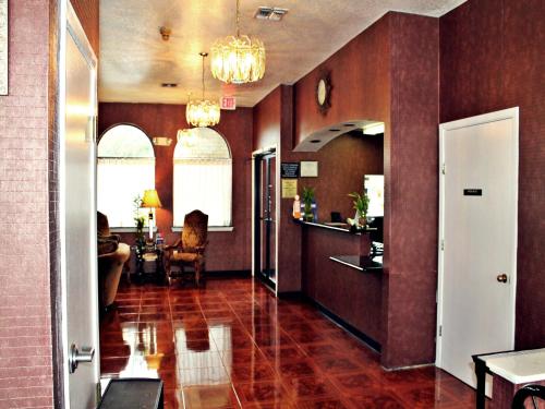 a living room with red tile floors and a hallway at Super 8 by Wyndham San Antonio at I-10 in San Antonio