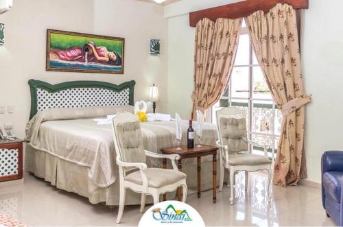 a bedroom with a bed and a table and chairs at Hotel Sinai in Nagua