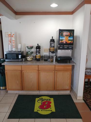 a kitchen with a counter with a television and a counter top at Super 8 by Wyndham New Cumberland in New Cumberland