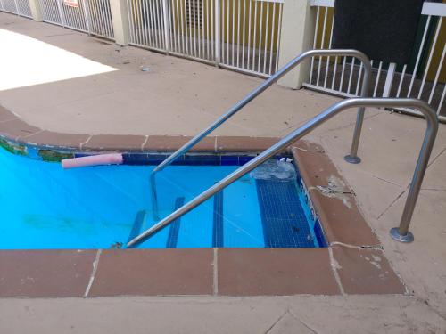 a swimming pool with a metal railing in the middle at Super 8 by Wyndham New Cumberland in New Cumberland