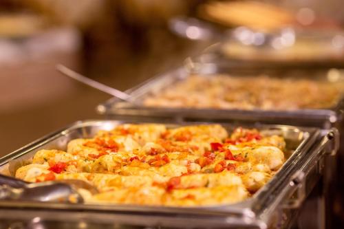 a row of trays of food in a buffet at Hotel Fazenda Vilarejo All Inclusive in Conservatória
