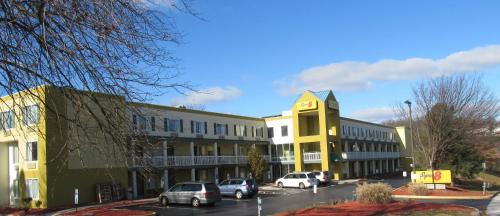 a yellow building with cars parked in a parking lot at Super 8 by Wyndham New Cumberland in New Cumberland