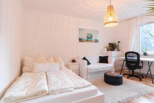 - un salon blanc avec un lit et un bureau dans l'établissement E&K Cityapartments, à Wuppertal