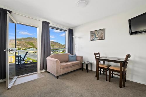 a living room with a table and a chair and a window at Central Gateway Motel in Cromwell