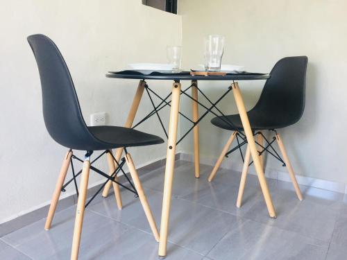 a table with two chairs and a table with glasses on it at La casa de Leslie - Apartment 2 in Mérida