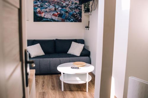 a living room with a blue couch and a white table at Voal Mini Apartament in Lublin