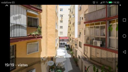 twee foto's van een steegje tussen twee gebouwen bij tranquilidad en el centro de la ciudad in Málaga