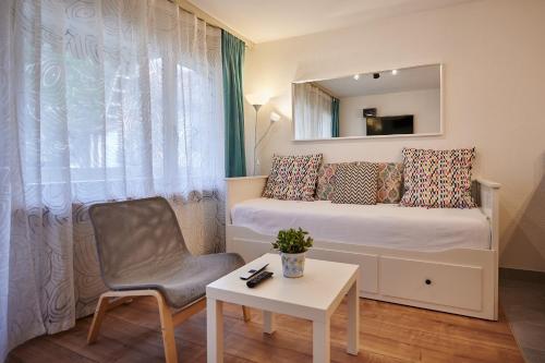 a small room with a bed and a chair and a table at Stay Switzerland Apartments in Interlaken