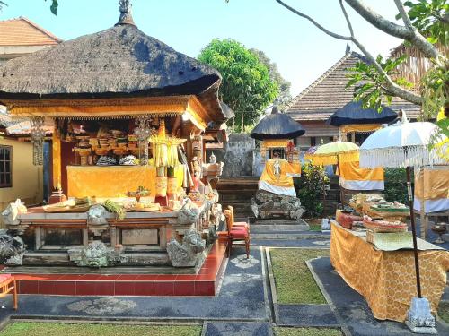a temple with a counter with food in front of it at Odah Ayu Guest House in Ubud