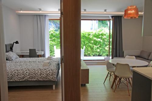 ソポトにあるLoveSopot Luxury Garden Apartmentのベッドルーム1室(ベッド1台、テーブル、テーブル付)