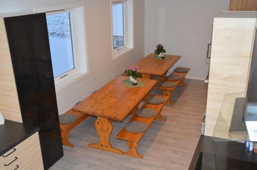 a long wooden table and chairs in a room at Haugo Utleige Lodge in Vossevangen