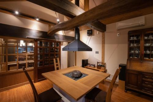 a dining room with a wooden table and a chandelier at inn NOSHIYU in Minamioguni