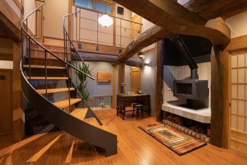 a spiral staircase in a room with a fireplace at inn NOSHIYU in Minamioguni
