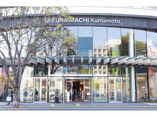 a large glass building with people walking in front of it at Place Hotel Ascot in Kumamoto