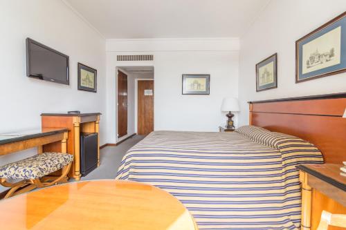 a hotel room with a bed and a desk at Hotel Libertador in Tandil