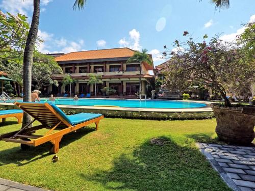 a resort with a swimming pool and a building at Masainn Hotel Kuta in Kuta