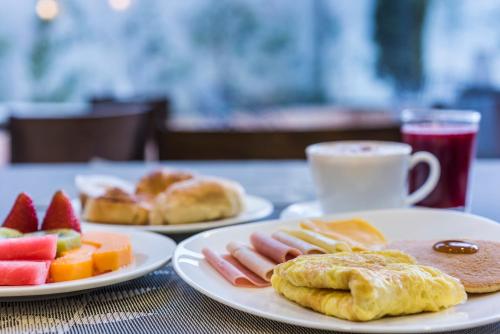 a table with two plates of food and a cup of coffee at Holiday Inn Express Quito by IHG in Quito