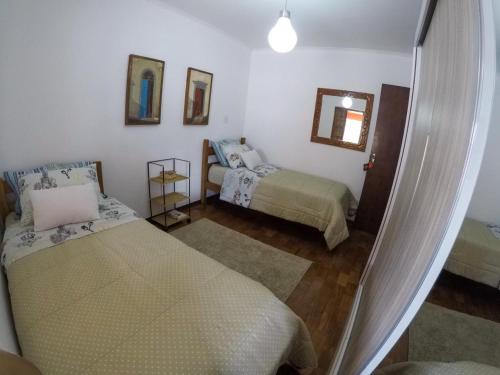um quarto com 2 camas e um espelho em Corona Hostel em Poços de Caldas