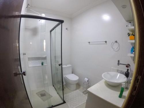 a bathroom with a shower and a toilet and a sink at Corona Hostel in Poços de Caldas