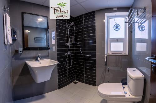 uma casa de banho com um lavatório e um WC em Palms Residence Inn دار النخيل em Nizwa