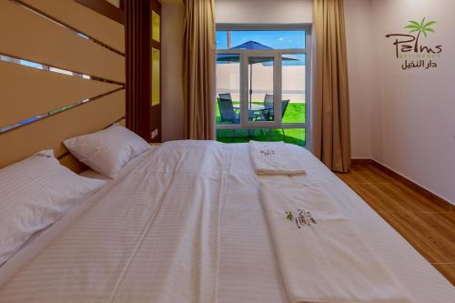 Postel nebo postele na pokoji v ubytování Palms Residence Inn دار النخيل