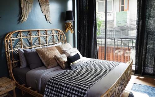 uma cama com almofadas num quarto com uma janela em NIL BKK em Bangkok