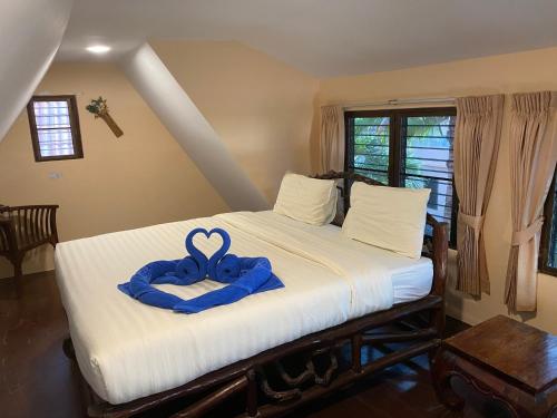 a bedroom with a bed with a blue ribbon on it at Laguna Beach Club Resort in Ko Lanta
