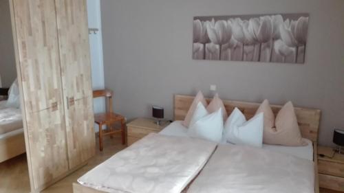 sypialnia z łóżkiem z białą pościelą i poduszkami w obiekcie Ferienwohnung Wohlesser w mieście Annaberg im Lammertal
