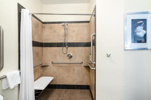 a bathroom with a shower and a toilet at Candlewood Suites Auburn, an IHG Hotel in Auburn