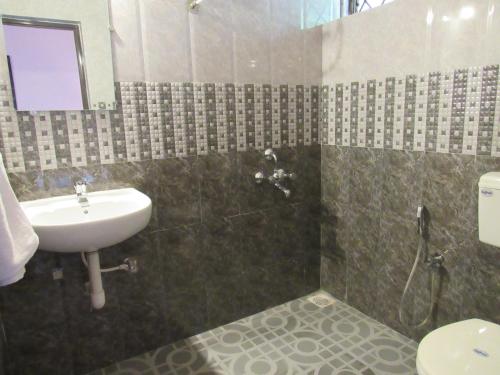 a bathroom with a sink and a toilet and a shower at TGF Dream Guest House in Majorda