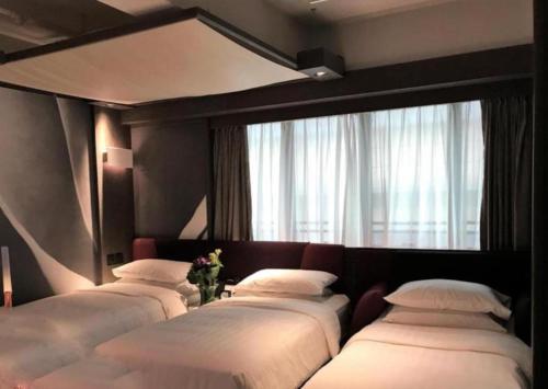 a group of four beds in a room with a window at Premium Lounge in Hong Kong