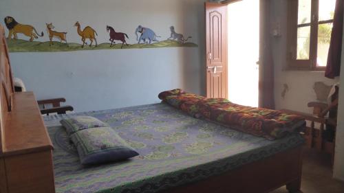 a bedroom with a bed with pillows on it at Haveli Elephant Stable in Būndi