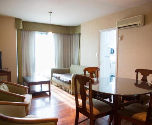 sala de estar con mesa y sofá en Millennium Apartments en Mendoza